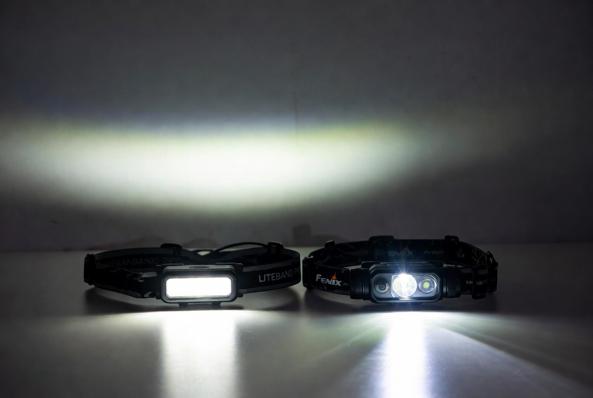 Two headlamps mounted on a flat surface with beams showing flood vs throw